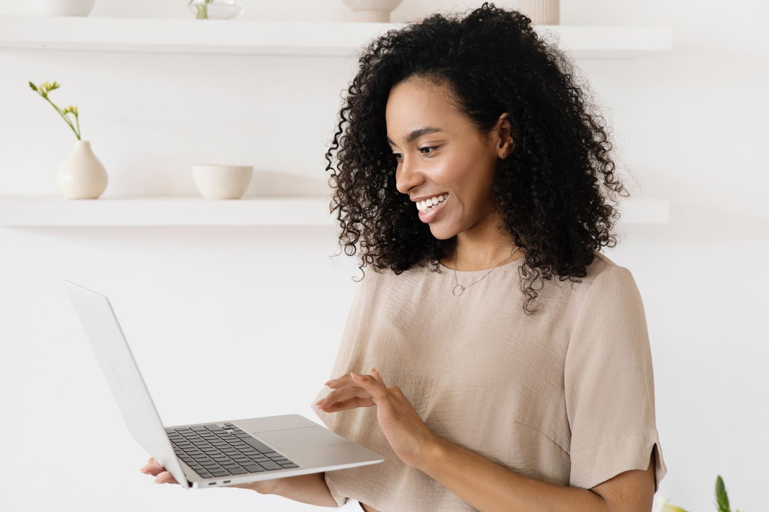 Smiling woman using laptop indoors.