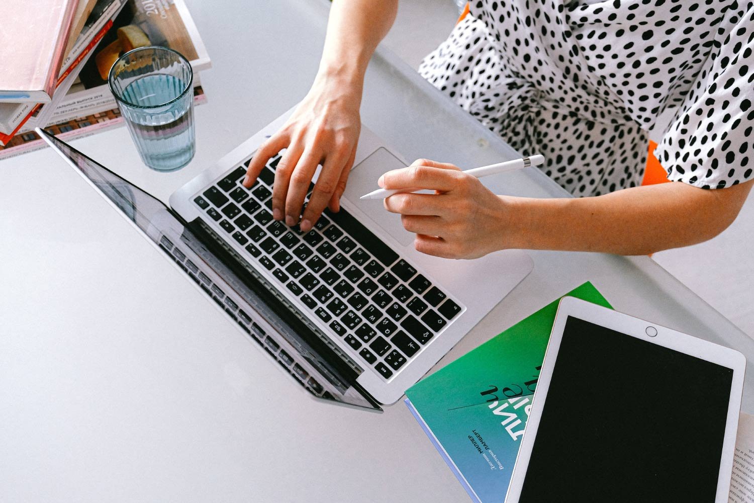 Woman working on laptop, stylus.